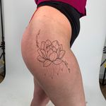 Beautiful fine line tattoo featuring a delicate lotus flower design by talented artist Chloe Hartland.
