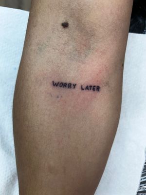 Delicate small lettering tattoo by Jonathan Glick, perfect for a minimalist and sophisticated look.