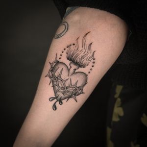 Get a stunning black and gray sacred heart tattoo by Jenny Dubet. A symbol of love and devotion.
