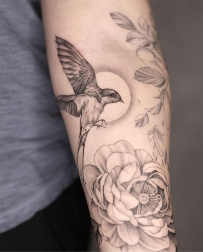 Inspired by traditional style, artist Kayla captures the beauty of a swallow and flower in black and gray ink.