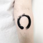 Unique blackwork and watercolor tattoo by Malvina Maria Wisniewska, featuring a serene enso circle and brush motif.