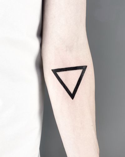 Explore the minimalist beauty of blackwork with this intricate geometric triangle tattoo by artist Malvina Maria Wisniewska.