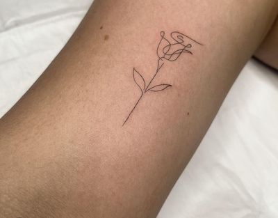 Admire the intricate beauty of this fine line rose tattoo, created with a delicate and dainty touch by artist Amelia.