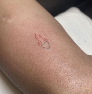 Get a beautifully intricate tattoo of a heart engulfed in flames, created with fine line details by talented artist Amelia.
