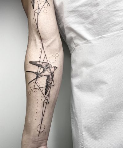 Elegant fine line geometric swallow design by Malvina Maria Wisniewska, perfect for subtle and stylish body art.