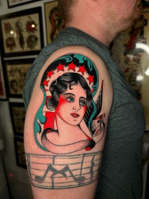 Beautiful traditional tattoo featuring an eagle and a lady, expertly executed by Ryan Goodrum.