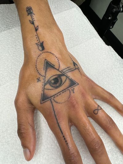 Unique and modern tattoo design featuring a geometric interpretation of a rose, triangle, and eye by Ryan Goodrum.
