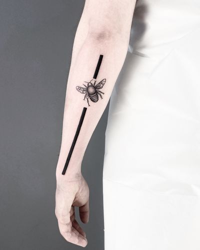 Unique blackwork tattoo featuring a geometric bee design by the talented artist Malvina Maria Wisniewska.