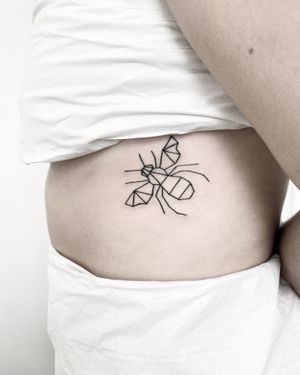Unique fine line bee design with geometric details by tattoo artist Malvina Maria Wisniewska.
