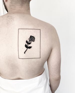 Beautiful blackwork fine line tattoo featuring a geometric rose within a frame, done by Malvina Maria Wisniewska.