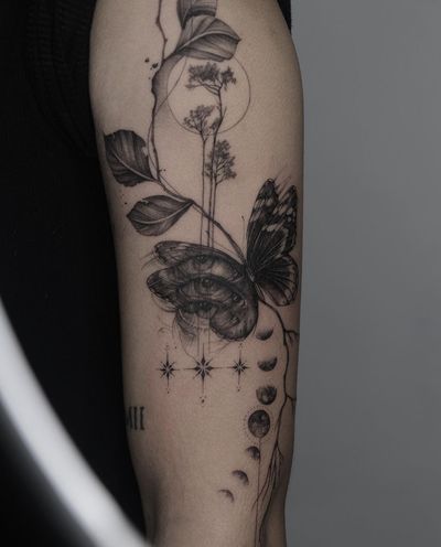 A stunning black and gray illustrative tattoo featuring a moon, butterfly, tree, and eye. Created by the talented artist Kayla.