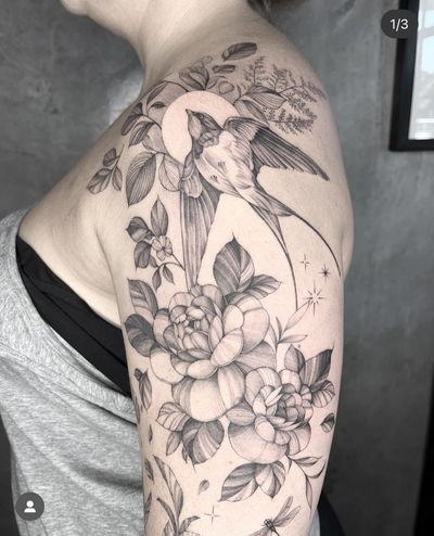 Elegant black and gray illustration combining a swallow and flower, expertly done by tattoo artist Kayla.