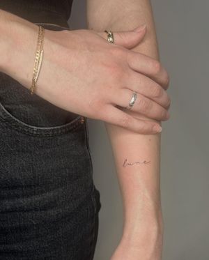 Get a delicate fine line tattoo with small lettering by Amelia for a subtle and sophisticated look.