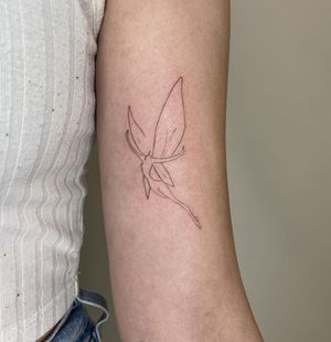 Get enchanted with this fine-line, illustrative fairy tattoo created by the talented artist, Amelia.