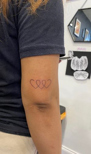 Elegantly designed by Sophia Hayes, this delicate single-line heart tattoo is perfect for those seeking a dainty and timeless piece of art.
