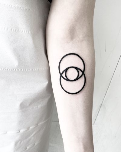 Blackwork tattoo by Malvina Maria Wisniewska featuring a mesmerizing eye design within overlapping circles.