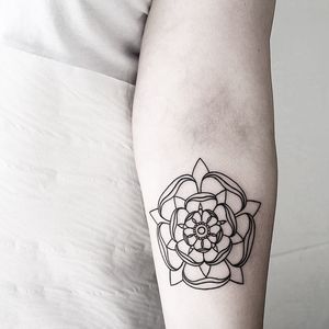Get a stunning illustrative Tudor rose tattoo by the talented artist Malvina Maria Wisniewska. This timeless motif will make a beautiful and elegant addition to your body art collection.