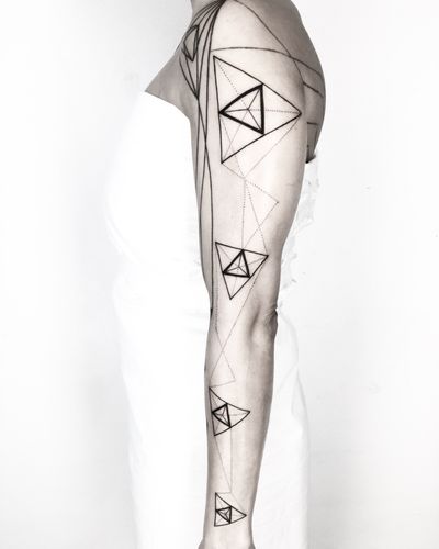 Unique blackwork tattoo with a geometric triangle motif, designed by Malvina Maria Wisniewska.