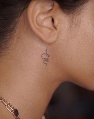 Experience the artistry of fine line and hand-poked techniques with this elegant snake motif by tattoo artist Anna. Perfect for those seeking a unique and personalized design.