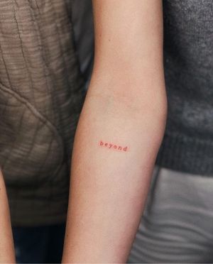 Get a unique and delicate hand-poked tattoo in red ink with small lettering by renowned artist Anna.