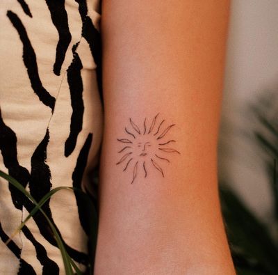 Experience the beauty of hand-poked dotwork with this delicate sun tattoo, expertly done by Anna.