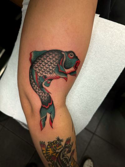 Experience the bold and classic style of traditional tattooing with a stunning fish motif by the talented artist Ryan Goodrum.