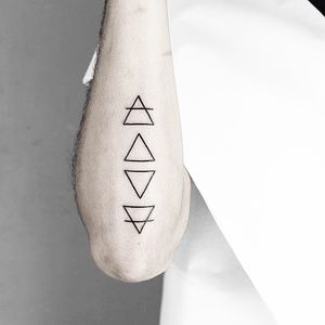 Elegant fine line tattoo by Malvina Maria Wisniewska, featuring a beautifully crafted triangle symbol design.
