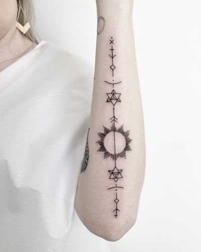 Discover the perfect blend of fine line art and geometric design in this striking tattoo by Malvina Maria Wisniewska.