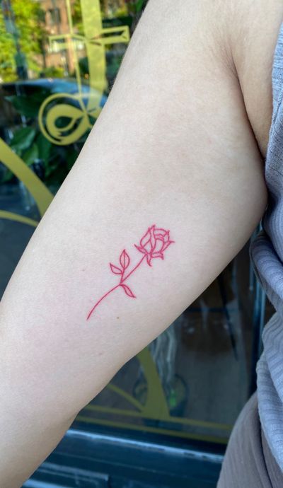 Sophia Hayes' exquisite fine line red ink rose tattoo is a timeless symbol of love and beauty.