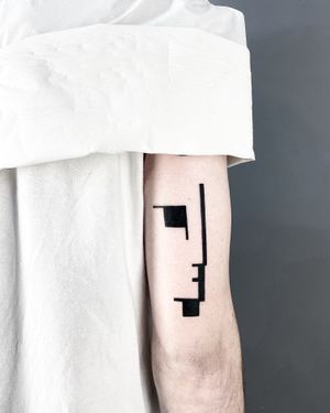Get inked with a striking blackwork tattoo of a Moai face, expertly done by Malvina Maria Wisniewska.