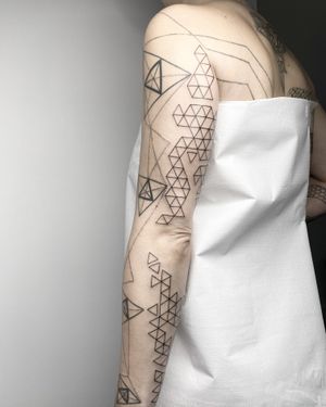 Discover the mesmerizing precision of Malvina Maria Wisniewska's geometric fine line pattern tattoo. An elegant fusion of art and geometry.