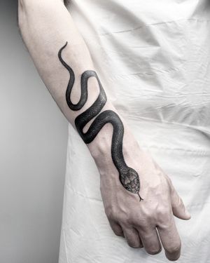 Striking black and gray illustrative snake tattoo by Malvina Maria Wisniewska. Perfect balance of realism and artistry.