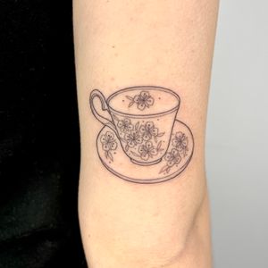 Get a charming illustrative tattoo featuring a tea cup design by the talented artist Michelle Harrison. Perfect for tea lovers!