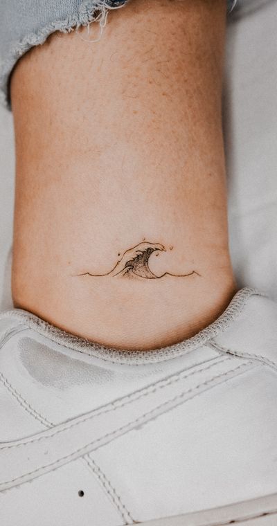 Fine line tattoo by Gabriele Edu combining a graceful wave motif with intricate detailing.