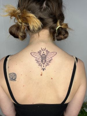 Unique dotwork tattoo featuring a beautiful flower and intricate cicada design by Michelle Harrison.