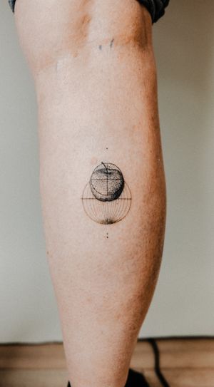Explore the fusion of nature and technology with this fine line black and gray tattoo by Gabriele Edu. Featuring a micro_realism apple surrounded by geometric wireframe and poles.