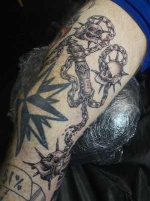 Unique dotwork tattoo featuring a skull, weapon, and chain, designed by the talented artist Kat Jennings.