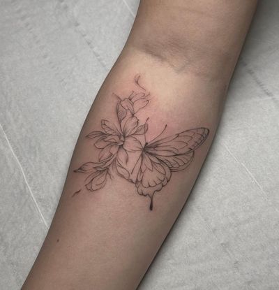 Elegant and intricate fine line illustration of a butterfly and flower, beautifully crafted by tattoo artist Maddie.