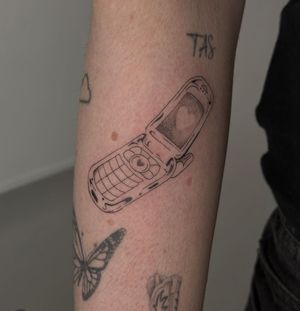Get a sleek, vintage vibe with this dotwork flip phone tattoo by talented artist Maddie. Perfect for tech lovers!
