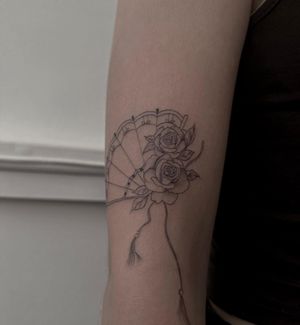 Get a beautiful and intricate fine line illustrative tattoo of a rose and fan by the talented artist Maddie.