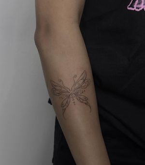 Adorn your skin with a delicate fine line butterfly by the talented artist Maddie. Achieve a whimsical and illustrative look.