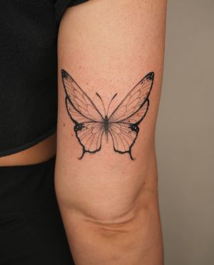 An illustrative tattoo by Lucas Scardua featuring a delicate butterfly design.