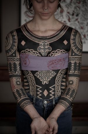 Embrace the ancient art of blackwork with this ornamental tribal pattern tattoo by Francesco Capro.