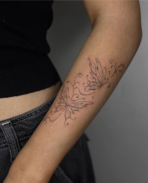 Admire the intricate beauty of this fine line butterfly tattoo done by the talented artist Maddie. A symbol of transformation and grace.