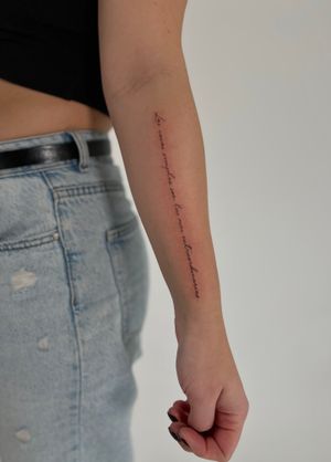 Elegant fine line and small lettering tattoo by renowned artist Faith Llewellyn. Perfect for a subtle and sophisticated look.