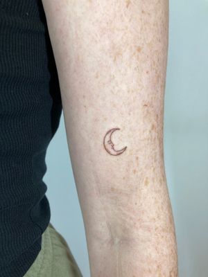 Experience the beauty of a fine line moon tattoo by artist Gee. This delicate design is perfect for those who appreciate subtle and elegant body art.