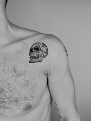 Embrace the dark beauty with this detailed black and gray skull tattoo. Ruth Hall's micro realism technique brings this macabre motif to life.
