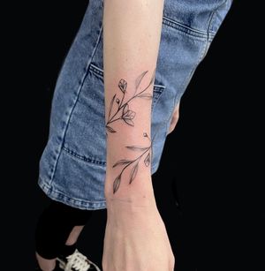 Embrace nature with this stunning tattoo of a delicate flower and branch, expertly inked by the talented artist, Rose Harley.