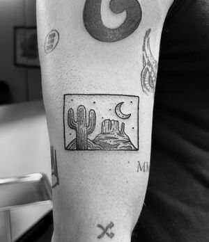 Gabriele Lacerenza's bold ignorant style tattoo featuring a desert landscape framed within intricate details.