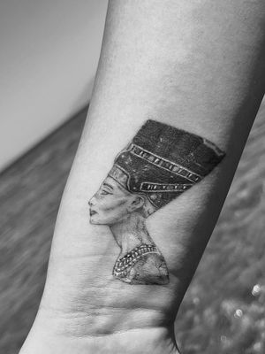 Get mesmerized by this stunning black and gray illustrative tattoo featuring the iconic Egyptian queen, Nefertiti, brought to life by the talented artist Gabriele Lacerenza.
